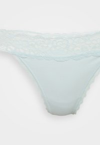 Lichtblauwe damesonderbroek met kanten tailleband en gegolfde randen op een effen achtergrond.