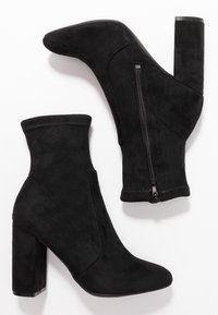 Schwarze Wildleder-Ankle-Boots mit spitzer Zehenform, Blockabsatz und seitlichem Reißverschluss. Mit einem dehnbaren Obermaterial für eine enge Passform.