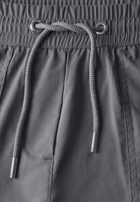 Grijze shorts van een textuurstof, met een elastische tailleband en een trekkoord geweven met zilveren accenten. Inclusief een zijzak.