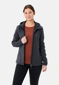 Donkergrijze zip-up hoodie gemaakt van zacht materiaal, met twee zijzakken en een gladde textuur. Draagt bovenop een roestkleurige top.