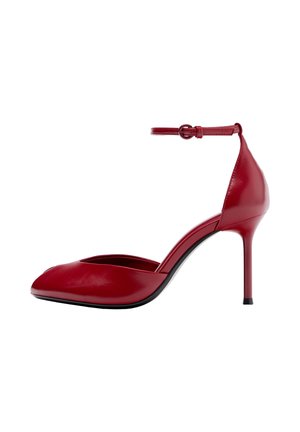 Scarpa con tacco a spillo alto in pelle rossa con punta appuntita e cinturino alla caviglia, tacco sottile, mostrata su sfondo bianco.