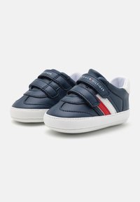 Tmavě modré kožené boty pro batolata s dvěma suchými zipy, bílou gumovou podrážkou a červenými a bílými pruhy. Logo na jazyku.