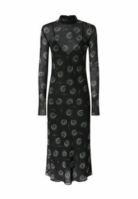 Crna haljina dugih rukava izrađena od prozirnog materijala sa spiralnim uzorcima i metalnim akcentima. Ima visoki ovratnik i lepršavu siluetu.