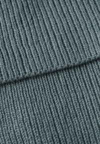 Tessuto a maglia testurizzato di un blu verde smorzato, caratterizzato da righe verticali e un aspetto morbido e accogliente.