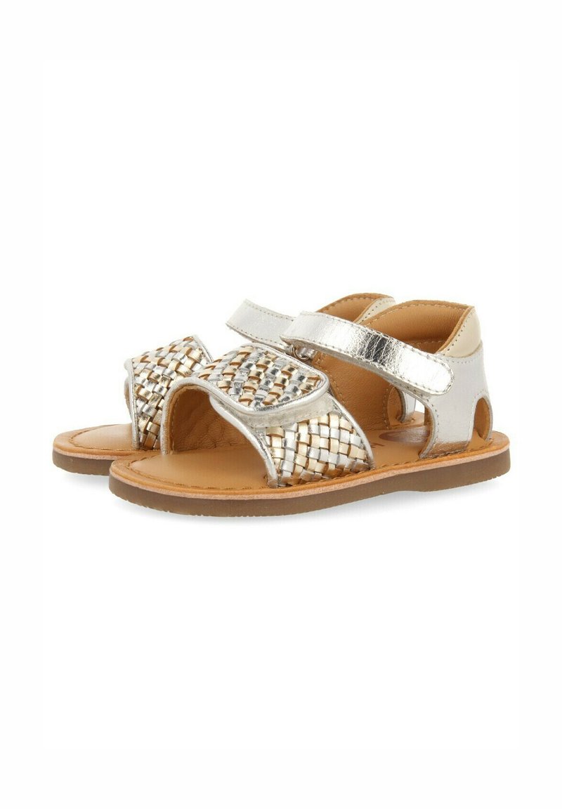 Sandales en cuir tressé argent et or avec une ouverture à l'avant, une sangle réglable et une semelle plate marron clair. Présente un design texturé.