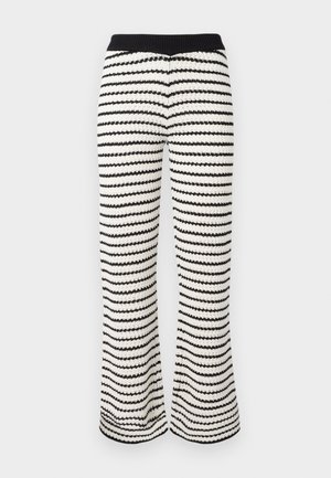 Pletené široké nohavice v čierno-bielych pruhovaných vzoroch. Obsahujú rebrovaný pás a textúrovanú tkaninu s vlnitým vzorom po celom povrchu.