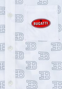 Camicia bianca con motivo ripetuto in grigio "EB" e un'etichetta ovale rossa con la scritta "BUGATTI" sulla tasca del petto. Design con bottoni fronte.