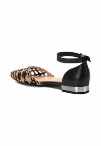 Zapato plano tejido en negro y beige con correa de tobillo y tacón de bloque metálico. Diseño de punta abierta con un patrón entrelazado en la parte superior.