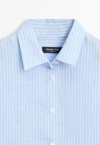 Hellblaues Hemd zum Knöpfen mit weißen vertikalen Streifen und spitzem Kragen, mit einem "Massimo Dutti" Etikett im Nackenbereich.