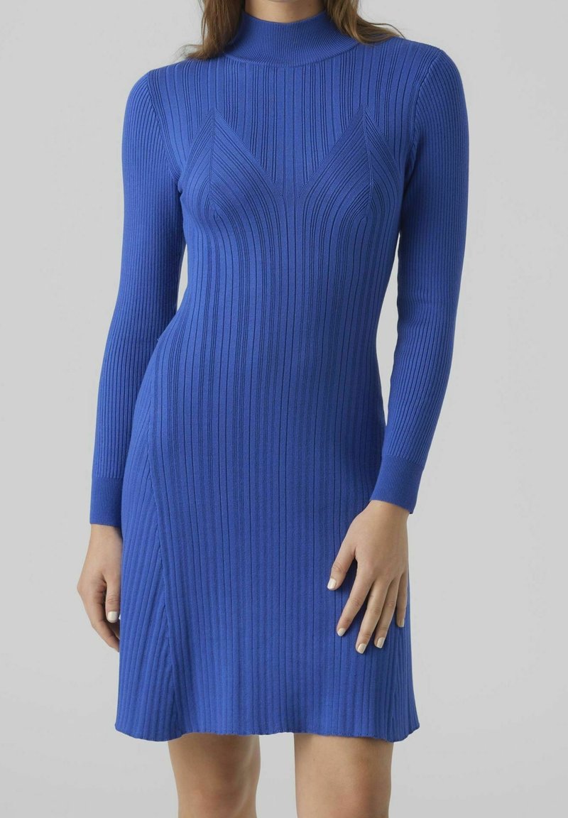Robe bleue côtelée avec un col haut, des manches longues et des coutures angulaires, offrant une silhouette ajustée qui s'étend jusqu'à mi-cuisse.