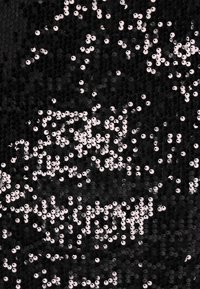 Fekete szövet fényes, kerek flitterekkel borítva; a flitterek különböző méretűek, és texturált felületet hoznak létre tükröződő kiemelésekkel.