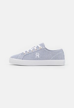 Casual lage sneaker met witte en marineblauwe verticale strepen, witte veters, metalen oogjes en een witte rubberen zool.
