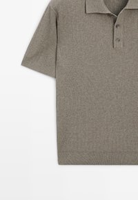 Polo gris à manches courtes en tricot côtelé avec col et patte à trois boutons sur fond blanc.