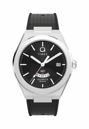 Mustade sihverplaatidega Timex kvartskell hõbedase korpusega, valgete tundmärkide ja kuupäeva näidikuga kella 3 asendis ning musta tekstuuriga rihmaga.