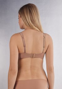 Hnědá saténová podprsenka s nastavitelnými ramínky a zapínáním na háček a očko na zadní straně, s hladkým povrchem a minimalistickým designem.