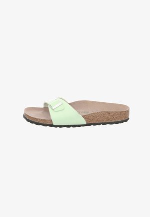 Green slide sandal with cork footbed, adjustable strap with silver buckle, textured black outsole, casual design.