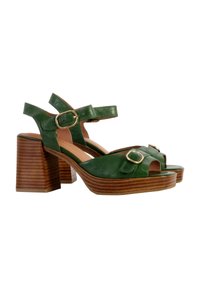 Sandalias de tacón alto de cuero verde con diseño de puntera abierta, que cuentan con dos correas ajustables en el tobillo y un tacón bloque de madera apilada texturizada.