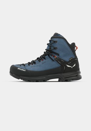 Blauw-zwart hikingboot met een suède bovenkant, rubberen neuskap en een gevoerde zool. Beschikt over grijze veters en een oranje accent op de hiel.
