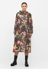 Kwiatowy kamuflażowy płaszcz przeciwdeszczowy z kapturem, w którego wzorach dominuje brąz, róż i czerwień. Zaprojektowany z długimi rękawami i długością do kolan.