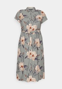 Kurzärmliges, knöpfbares Kleid aus hellgrünem Stoff mit großem Blumenmuster in Beige und Dunkellila. Gurtband in der Taille zur Anpassung der Passform.
