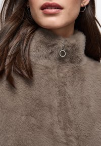 Brown faux fur fabric with a high collar, featuring a silver circular zipper pull, smooth texture, and soft, fluffy appearance.
