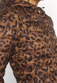 Giacca puffer con stampa leopardo marrone e cappuccio, caratterizzata da sezioni trapuntate, zip frontale e dettaglio con cordino sul cappuccio.