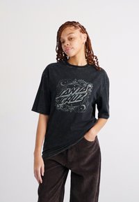 Tricou din bumbac negru cu mâneci scurte, având un design grafic care include textul "Santa Cruz" într-o fontă stilizată.