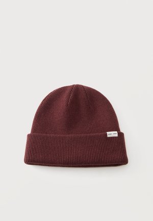 Burgundy ribbed knit beanie hat with folded cuff and small white label on plain light background.