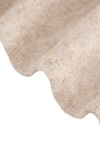 Jasnobeżowa tkanina o miękkiej, teksturowanej powierzchni, z subtelnym, puszystym wyglądem i płynnie zakrzywionymi krawędziami.