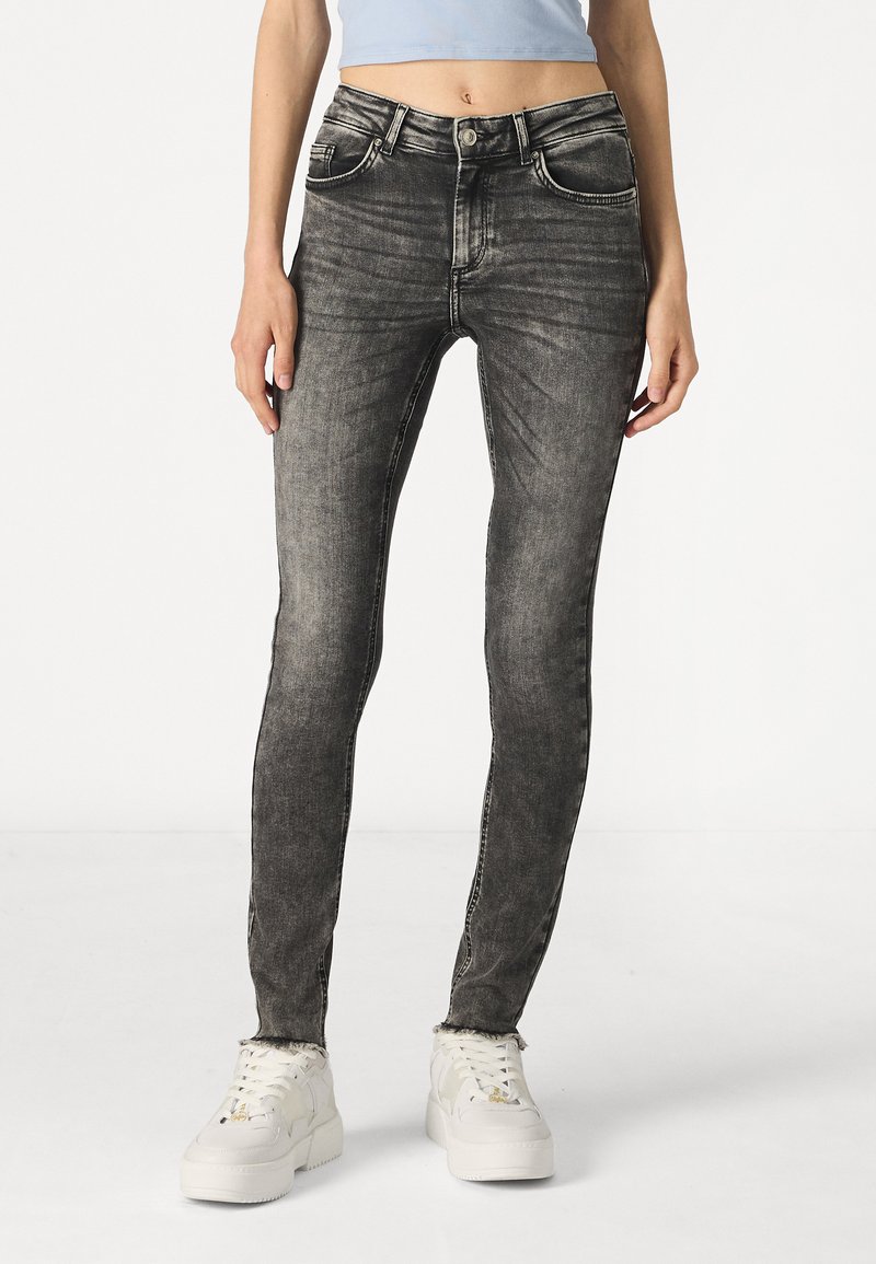 Jeans skinny en denim noir au look délavé, avec cinq poches et passants de ceinture. Coupés pour un ajustement serré, avec une légère élasticité pour le confort.