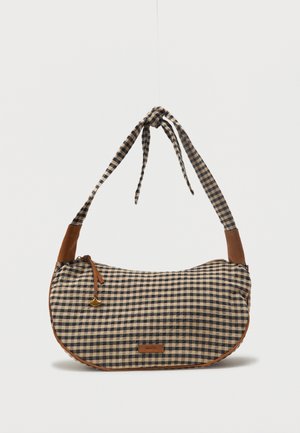 Sac à bandoulière à carreaux marron et beige avec une sangle nouée et des accents en cuir marron, équipé d'une fermeture éclair et d'une petite étiquette de marque.