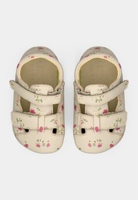 Δερμάτινα παπούτσια κρεμ χρώματος με ροζ λουλουδένια σχέδια, διαθέτουν δύο ρυθμιζόμενους ιμάντες με βέλκρο και ανοίγματα στη μύτη.