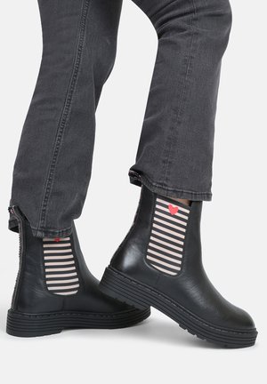 Schwarze Leder-Stiefeletten mit gestreiften elastischen Seitenpaneelen, die ein rotes Herz zeigen. Grober Absatz, elegantes Design und kontrastreiche Nähte.