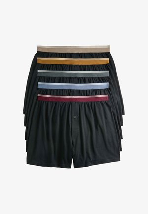Zwarte boxershorts in lagen gerangschikt, met contrasterende elastische taillebanden in beige, mosterd, groen, blauw en bordeauxrood, voorzien van knoopdetails.