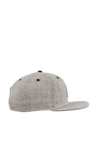 Grå caps med en strukturert flat skygge, laget av teksturert stoff. Har svarte luftelommer og en side-logo-patch.