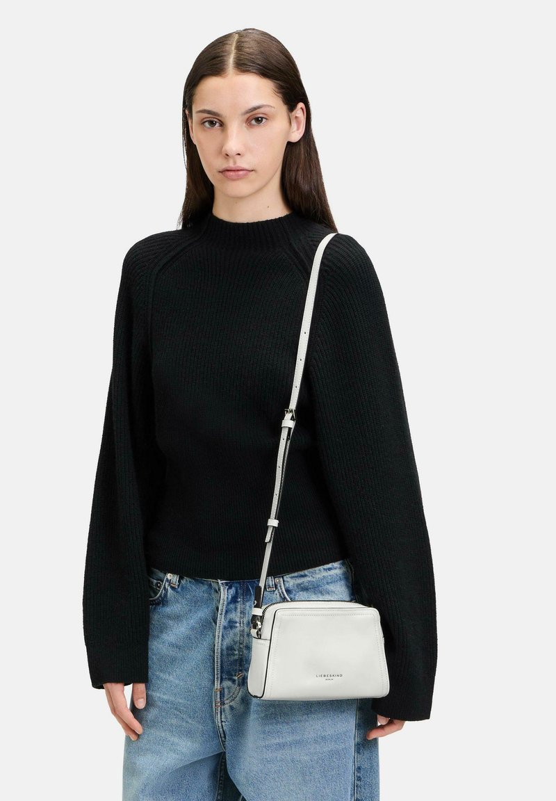 Witte leren schoudertas met een ritsluiting en een verstelbare band, met een soepele textuur en subtiele branding aan de voorkant.