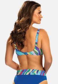 Kolorowy zestaw bikini z wielokolorowym wzorzystym topem z regulowanymi ramiączkami i jednolitym niebieskim dołem. Gładki, elastyczny materiał.
