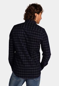 Marine flanellen shirt met een geruit patroon, lange mouwen, knoopsluiting en afgeronde zoom. De stof ziet er zacht en warm uit.