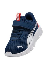 Zapatilla deportiva de malla azul con suela blanca, con una correa de velcro, acento rojo en el talón y logo blanco de Puma en el costado.