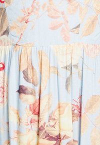 Kukallinen kangas vaaleansinisen taustan kanssa. Ominaisuuksina pehmeät, pastelliset värit ja teksturoitu pinta. Sisältää lehti- ja kukkakuoseja sekä poimutuksia.