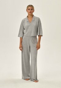 Szary dwu-częściowy zestaw do relaksu składający się z krótkiego topu w serek z szerokimi rękawami oraz luźnych spodni o wysokim stanie, wykonany z miękkiego materiału.