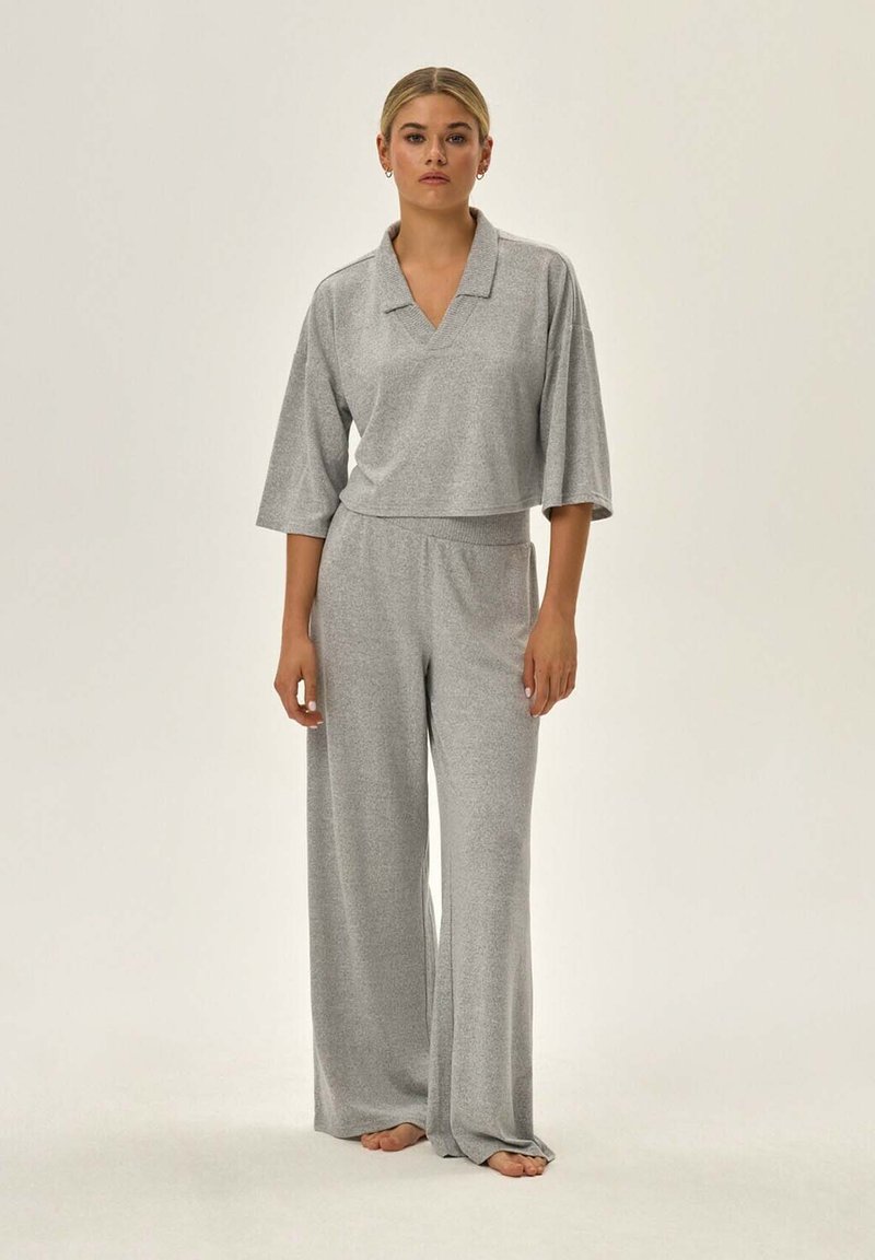 Szary dwu-częściowy zestaw do relaksu składający się z krótkiego topu w serek z szerokimi rękawami oraz luźnych spodni o wysokim stanie, wykonany z miękkiego materiału.