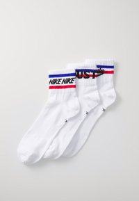 Calzini in cotone bianchi a cuffia con bande strisce rosse e blu nella parte superiore, con la scritta "NIKE NIKE" e "JUST" stampata in nero. Set di tre paia.