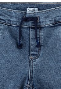 Denim-Shorts in einem hellblauen Farbton, mit verstellbarem Bund und sichtbaren Nähdetails. Der Stoff hat eine klassische gewebte Textur.