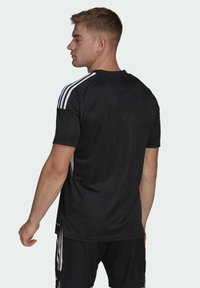 Black athletic jersey with a textured geometric design, featuring white stripes on the shoulders. Short sleeves and a crew neck.