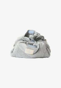 Grå snørepose laget av myk teksturert stoff, med rynket design og liten rektangulær merkeetikett i en naturlig nyanse.