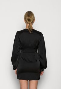 Mustesatiini mini mekko, jossa on pitkät, volyymsit muotoillut hihat ja vyöllä varustettu vyötärö. Sujuva pinta, yksinkertainen pyöreä pääntie ja muotoiltu istuvuus.