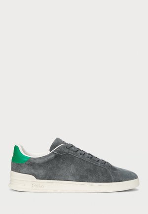 Szary zamszowy niski sneaker z białą podeszwą, zieloną pętlą na pięcie i wiązaniem na sznurówki, z wytłoczonym logo Polo po boku.
