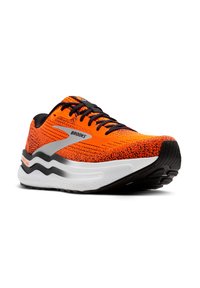 Zapatilla de running naranja con parte superior de punto, cordones negros y detalles plateados. Presenta una entresuela blanca con amortiguación y una suela exterior negra texturizada.