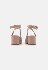 Pink, suede heeled sandals with an ankle strap and buckle, featuring a solid heel and wide, open back for comfort and stability.